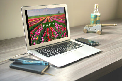 Laptop on a desk with a 'Free Plan' C++ course on screen, surrounded by stationery items.