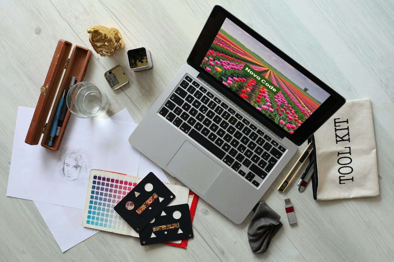 Laptop on a desk with stationery items and a screen displaying a C++ course cover 'Nova Code'